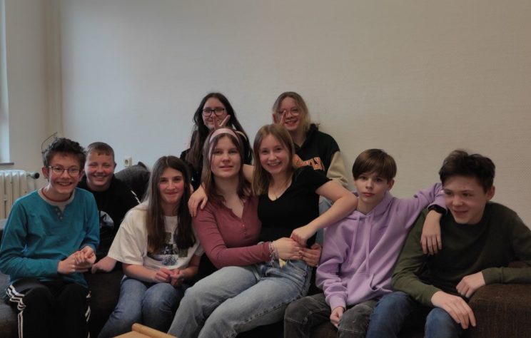 Das Team der Schülerinnenzeitung sitzt fröhlich gemeinsam auf einem Sofa.