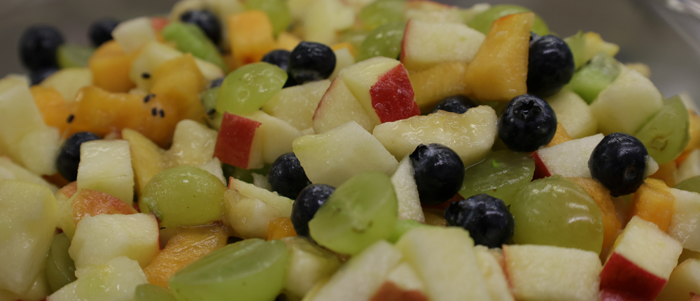 Ein Obstsalat mit Heidelbeeren, Weintrauben, Äpfeln und Pfirsichen.