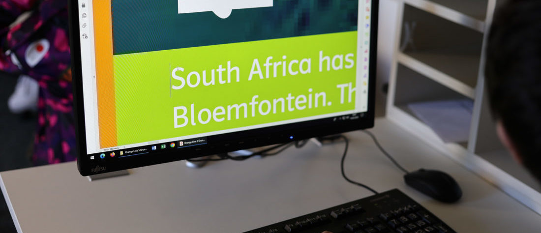 Ein Kind arbeitet an einem Computer. Auf dem Bildschirm sieht man die Schriftvergrößerung.