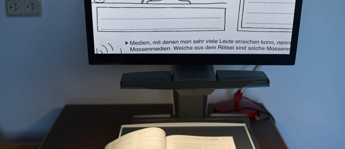 Ein Lesegerät, das über einen Monitor eine Vergrößerung anzeigt. Es wird verwendet, um Texte oder Bilder für eine bessere Lesbarkeit zu vergrößern und ist eine hilfreiche Unterstützung für Menschen mit eingeschränkter Sehkraft.