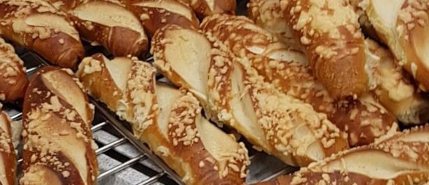 Mehrere goldbraune Laugenstangen mit Käse.