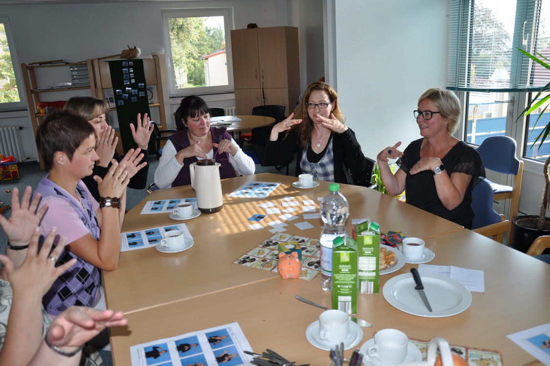 Erwachsene üben die Gebärdensprache.