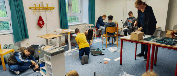 Kinder arbeiten in einem Raum am Aufbau von Hockern.