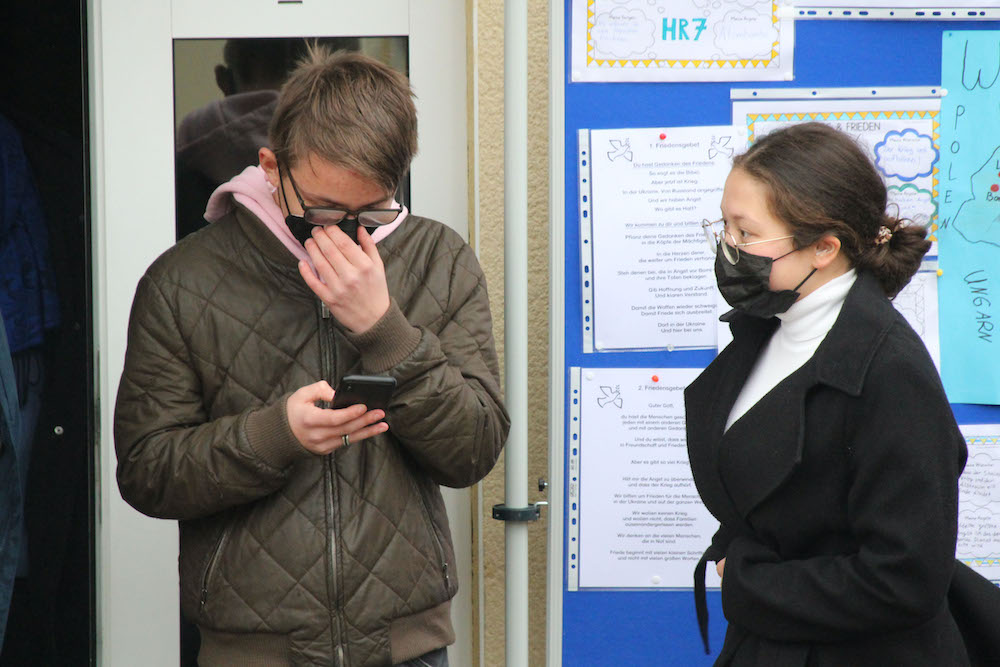 Eine Schülerin und ein Schüler lesen etwas vor.