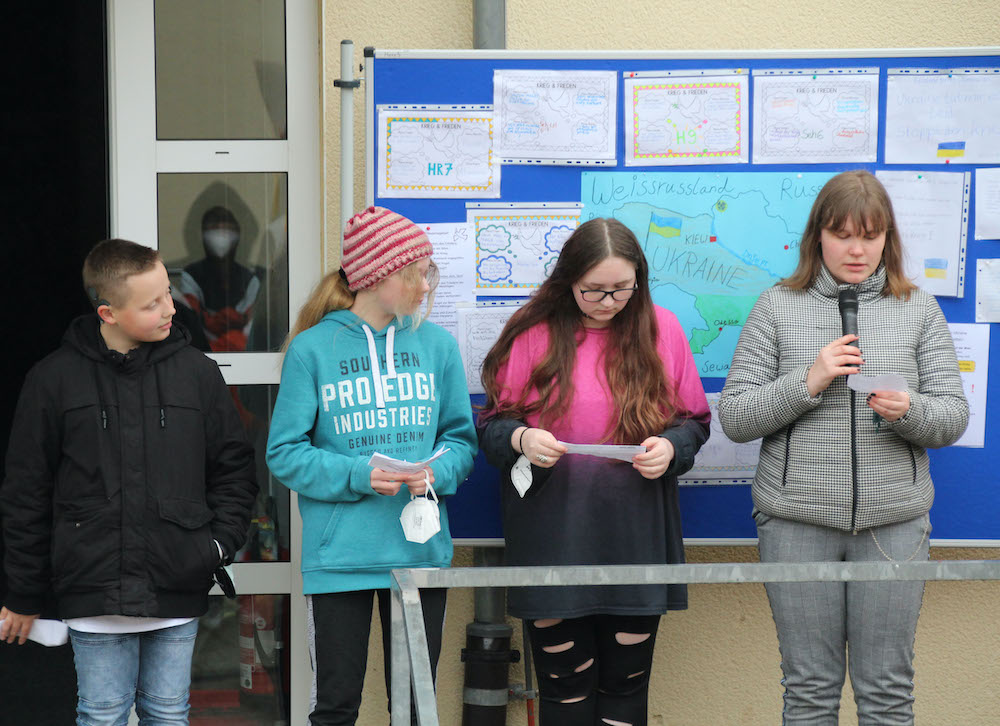 4 Schülerinnen und Schüler lesen etwas vor.