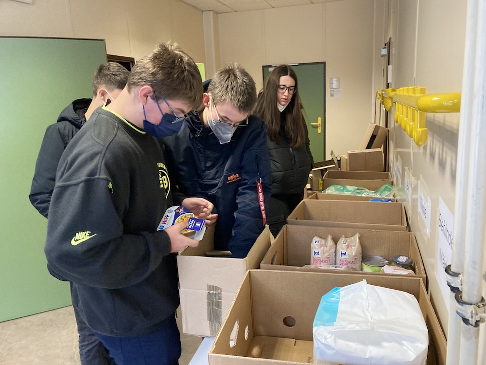 Schülerinnen und Schüler sortieren Spenden.