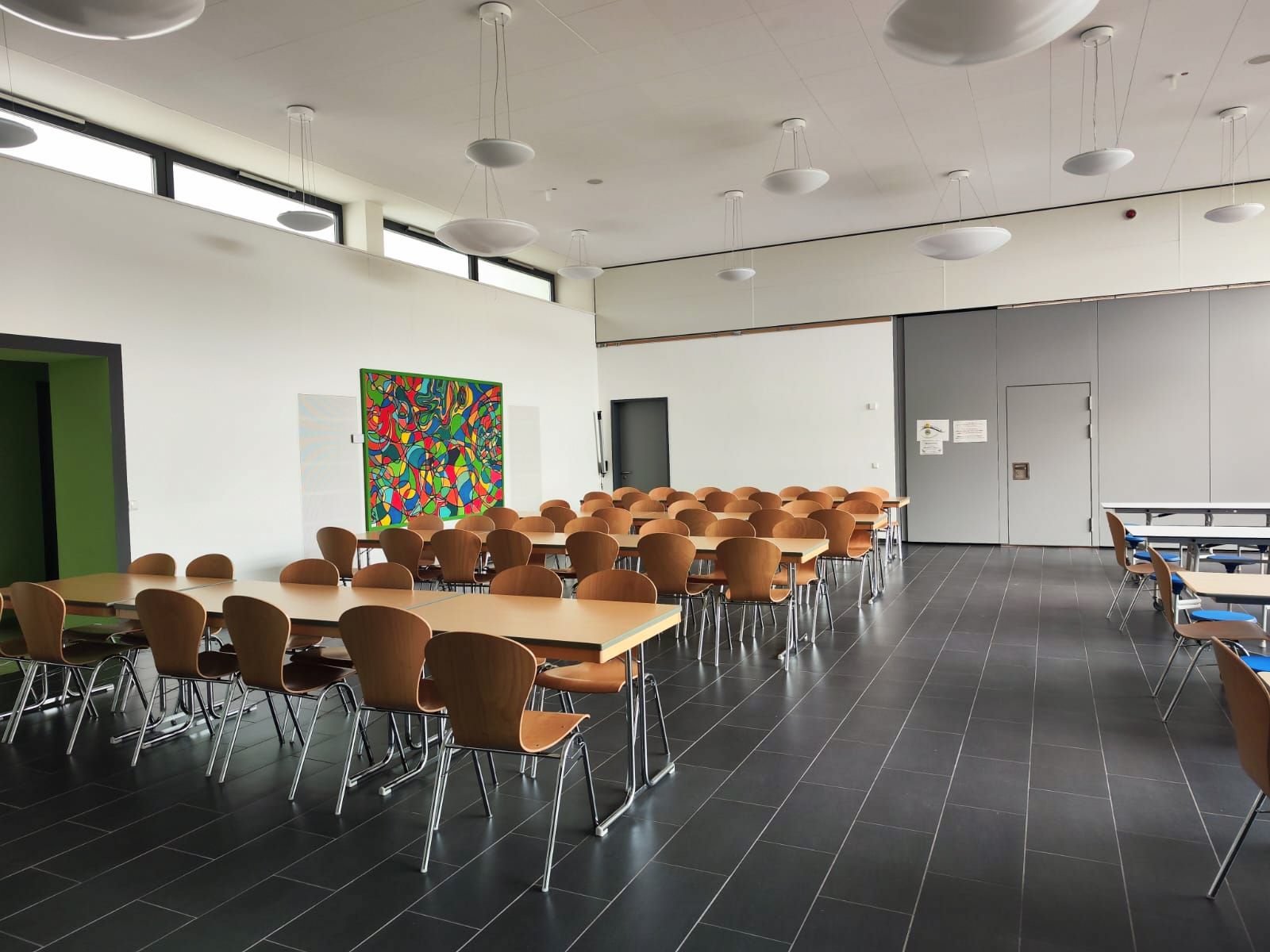 Die Mensa, mit vielen Tischen und Stühlen in einem großen Raum